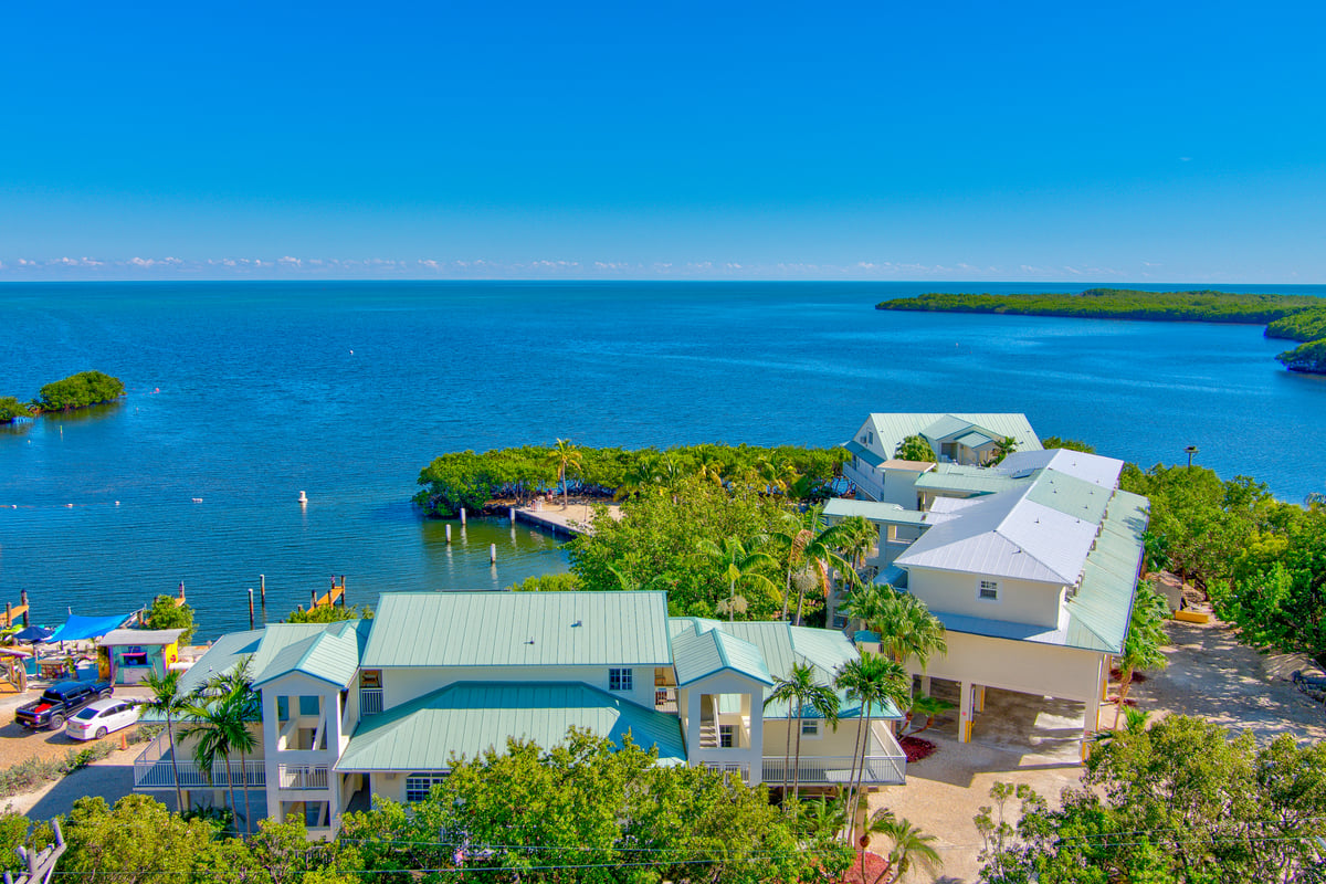 Aerial over Key Largo at Dove Creek on a clear morning, turquoise water and mangrove shoreline in both directions
