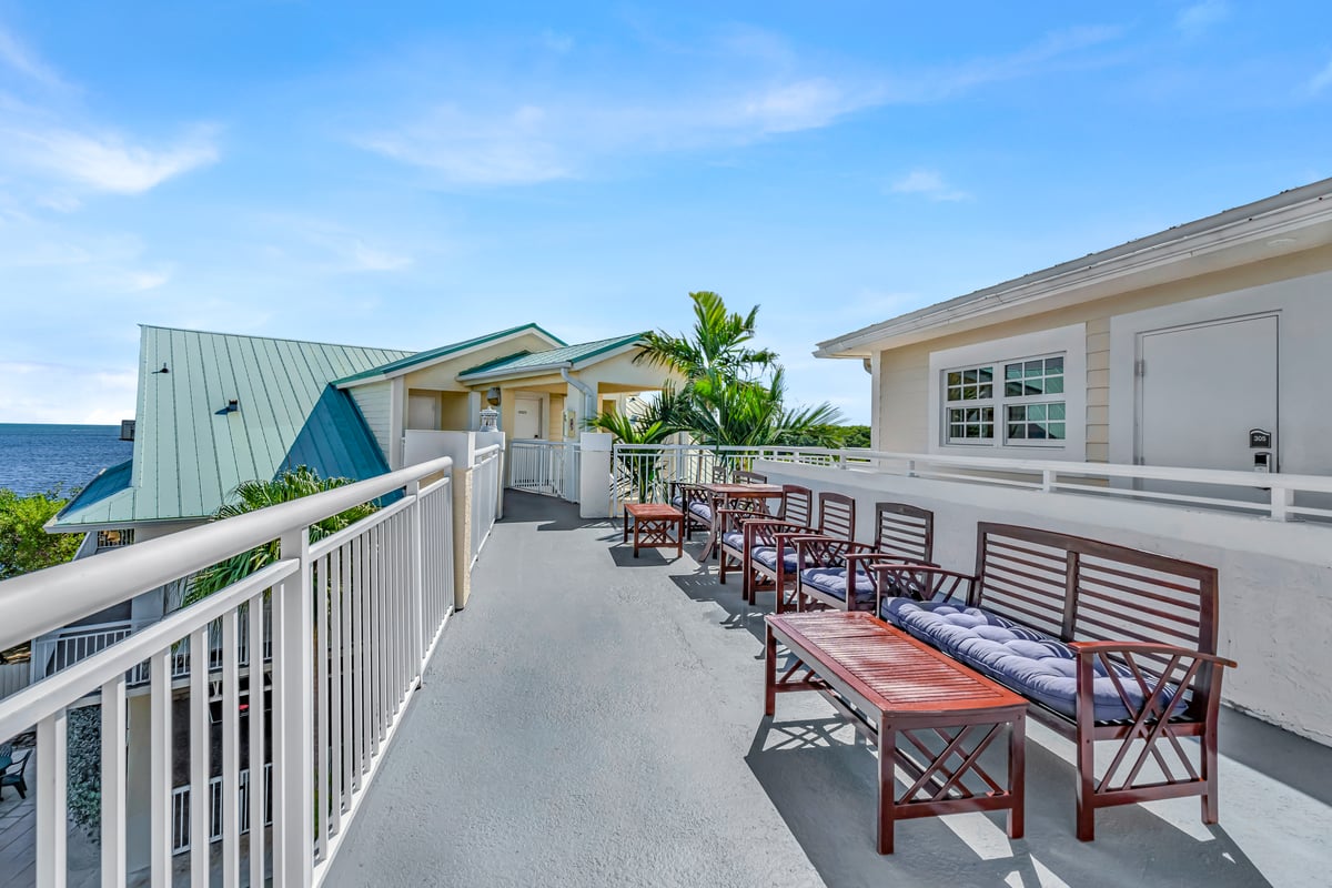 Breakfast on the Dove Creek Resort & Marina rooftop — pastries, fruit and mimosas on a blue-and-white bistro table above the sand