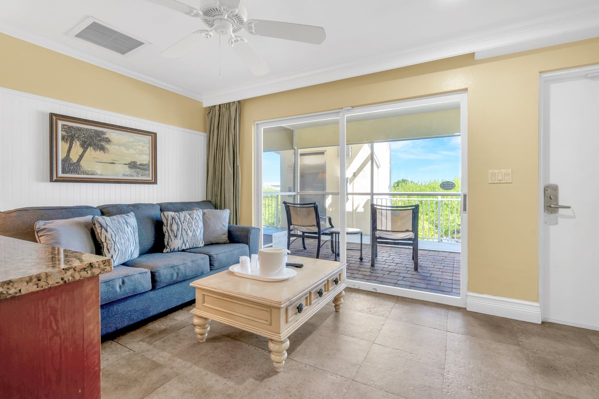 SNQ4 Deluxe Double Queen Suite living area, sofa and side table beside the balcony doors