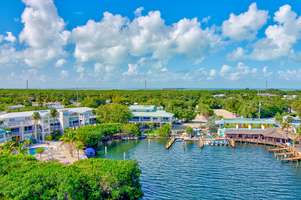 Aerial over the Dove Creek marina in Key Largo, boat slips along the dock and the channel running out to open water
