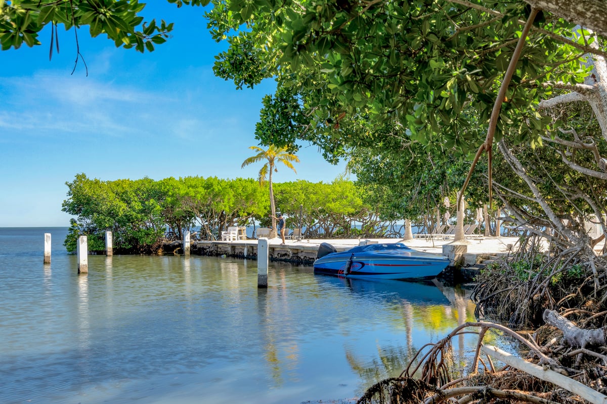 A small boat idling out through the mangrove cove at Dove Creek Resort & Marina toward open water
