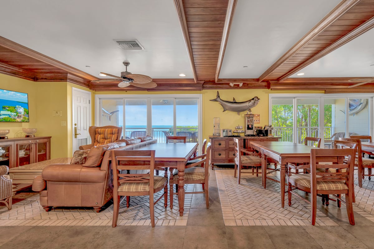 The Dove Creek breakfast lounge, laid tables and light seating with the water through the windows